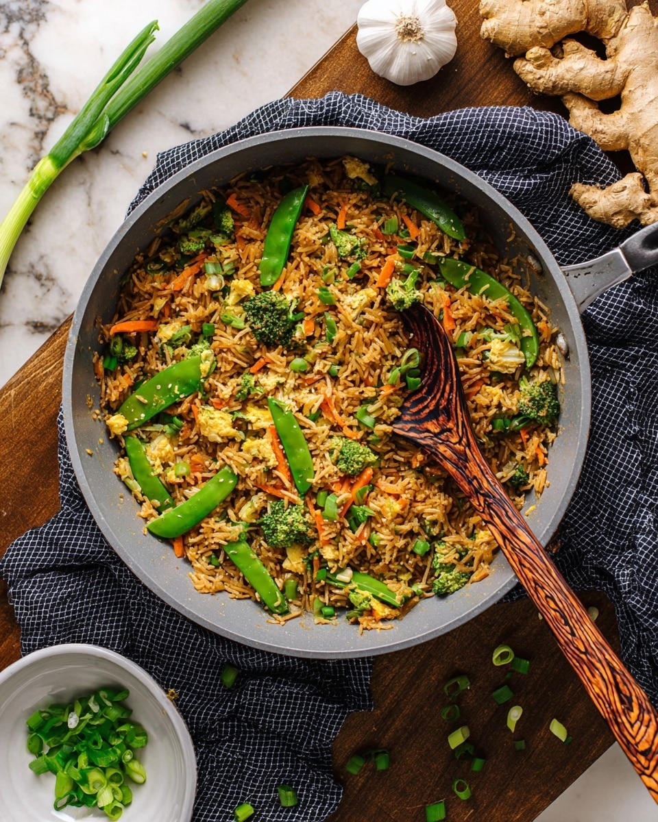 A large gray speckled pan filled with three main layers: at the bottom, there is a layer of brown cooked rice mixed with thin orange carrot strips and light bean sprouts; the middle layer has bright green snow peas and vibrant green broccoli pieces scattered evenly; the top layer is sprinkled with fresh green chopped scallions. A wooden spoon with a thin and dark wood grain handle rests inside the pan, with some of the rice and vegetables on it. Around the pan, on a white marbled surface, there is a small white bowl filled with sliced green scallions, pieces of ginger root, garlic cloves, and some green scallion pieces scattered. A black and white checkered cloth is under the pan handle. photo taken with an iphone --ar 4:5 --v 7
