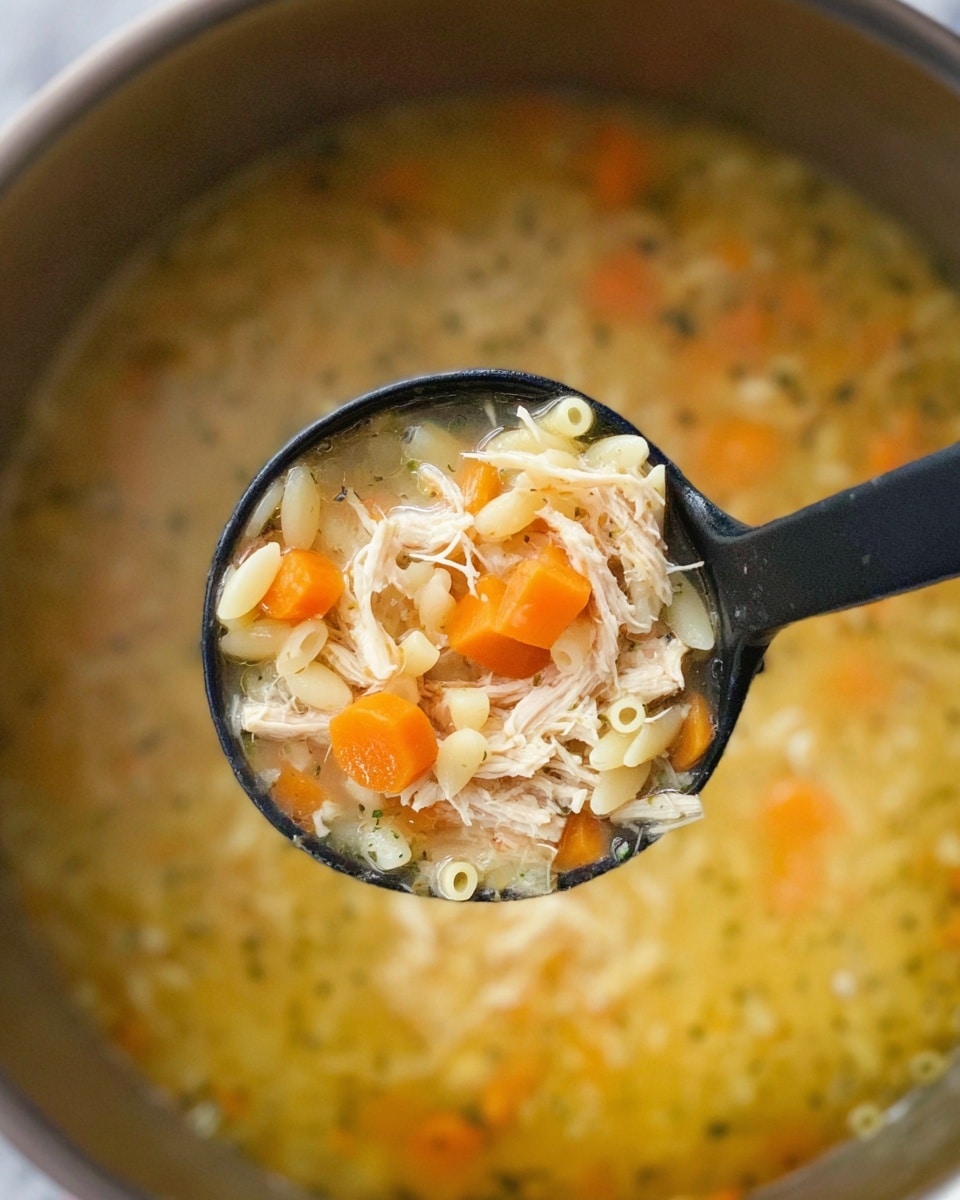 A shiny metal pot contains two large raw chicken pieces placed side by side on top of a layer of chopped orange carrots mixed with small bits of light green vegetables and herbs. A few green bay leaves are partially visible under the chicken. The carrots form the bottom layer with a slightly soft texture, while the chicken sits smoothly on top. The pot interior is reflective and clean. The background is changed to a white marbled texture photo taken with an iphone --ar 4:5 --v 7