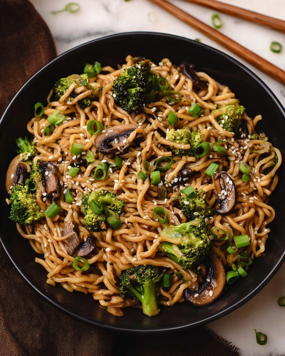 This image shows a black bowl filled with cooked noodles that have a light brown, glossy texture. Mixed in are small green broccoli florets and dark brown mushroom slices. There are also thin slices of green onions scattered on top, along with white sesame seeds evenly spread over the dish. The bowl sits on a white marbled surface, and a pair of wooden chopsticks lie nearby. Photo taken with an iphone --ar 4:5 --v 7