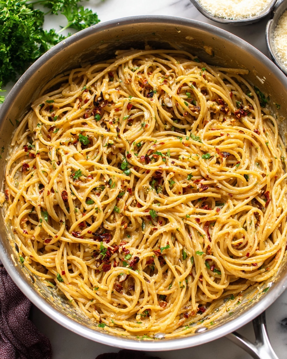 A large silver pot filled with long, thin spaghetti noodles coated in a creamy, light brown sauce with small bits of meat mixed throughout, the noodles are softly tangled and glossy with the sauce covering them evenly, the pot is placed on a wooden surface. photo taken with an iphone --ar 4:5 --v 7