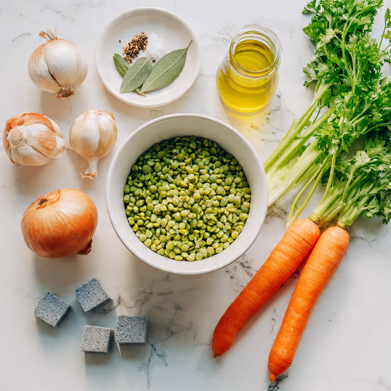 The image shows a white bowl filled with green split peas, placed on a white marbled surface. Nearby, there is a small glass jar of yellow oil, and a white dish holding bay leaves, pepper, and salt. Two whole orange carrots and a bunch of fresh green celery sit on the right side of the scene. Two whole onions are placed on the left side, and three garlic cloves and four gray bouillon cubes are arranged in front of the bowl and dish. A bunch of fresh green parsley is partially visible in the top right corner. The photo was taken with an iphone --ar 4:5 --v 7