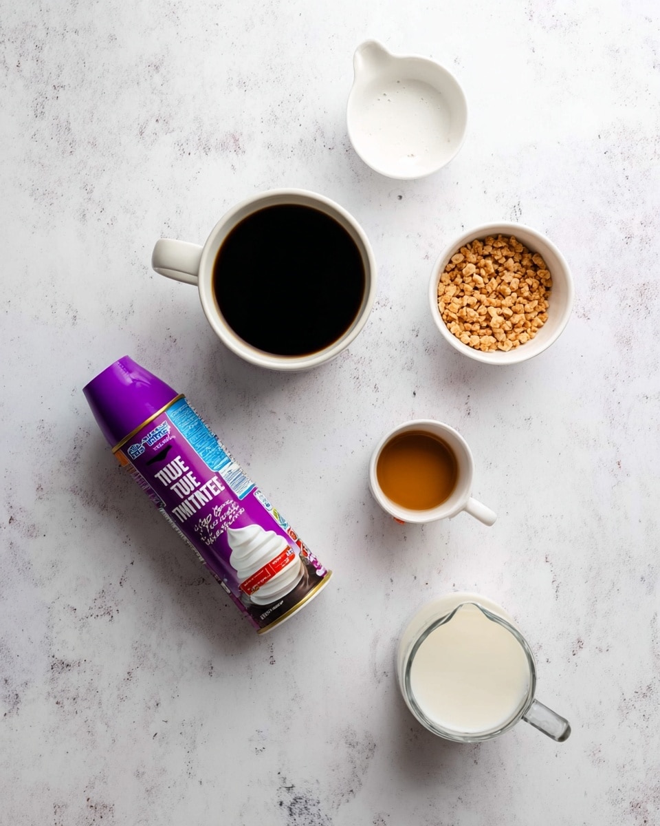 The image shows a flat lay of ingredients arranged on a white marbled surface: a can of whipped topping with a purple cap on the left, a white mug filled with black coffee at the top center, a small white bowl with light brown crunchy pieces below the coffee, a small white jug with light brown syrup on the right, and a small clear measuring cup with milk at the bottom right photo taken with an iphone --ar 4:5 --v 7