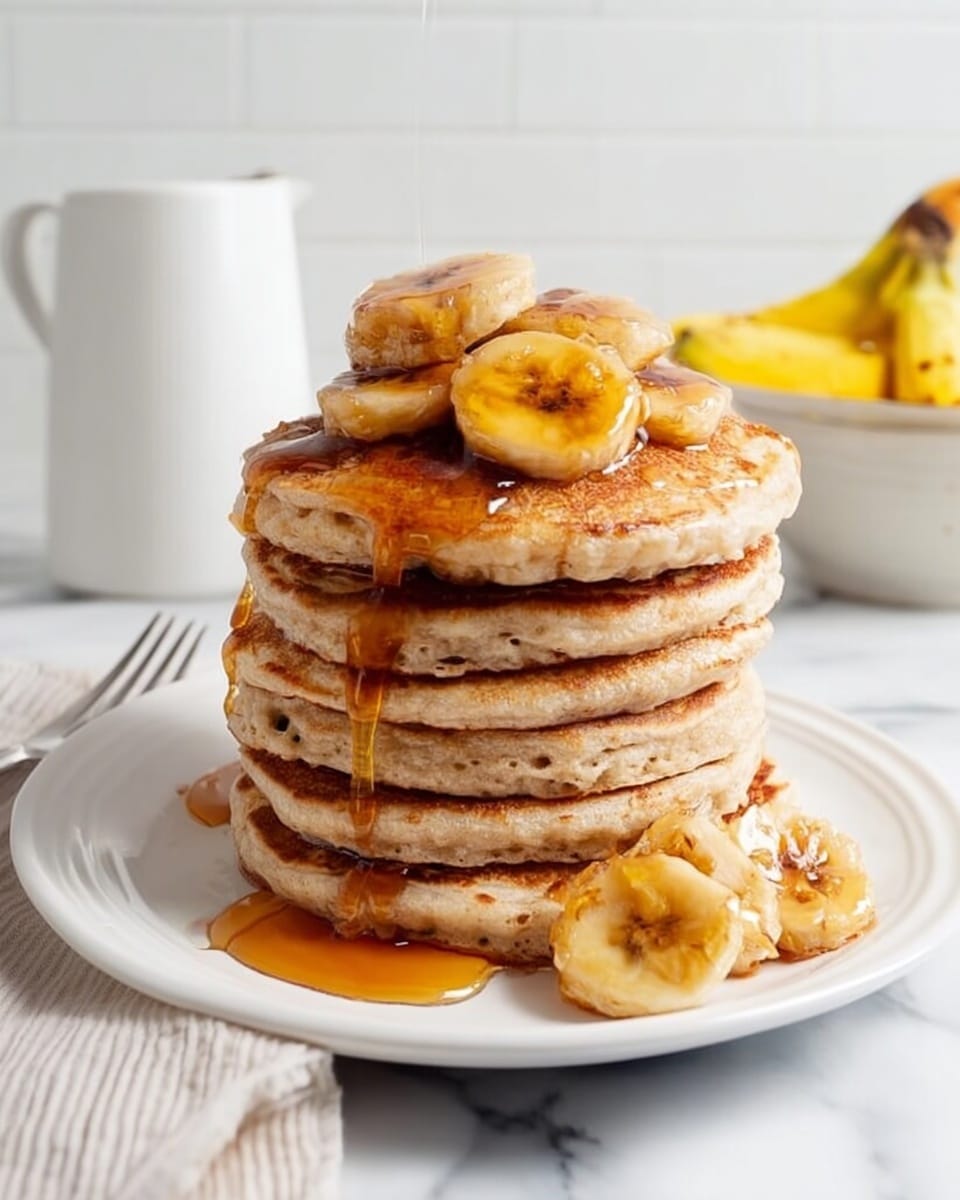A tall stack of six thick, golden-brown pancakes sits on a white plate, each layer showing small air holes and a soft texture. On top of the stack are several caramelized banana slices that are brown and shiny. Amber syrup is slowly dripping down the sides, covering the pancakes and pooling at the base. One caramelized banana slice rests beside the stack on the plate. The background is a white marbled surface with a white pitcher and a bowl of bananas blurred softly in the back, while a silver fork lays on a white cloth to the left. photo taken with an iphone --ar 4:5 --v 7