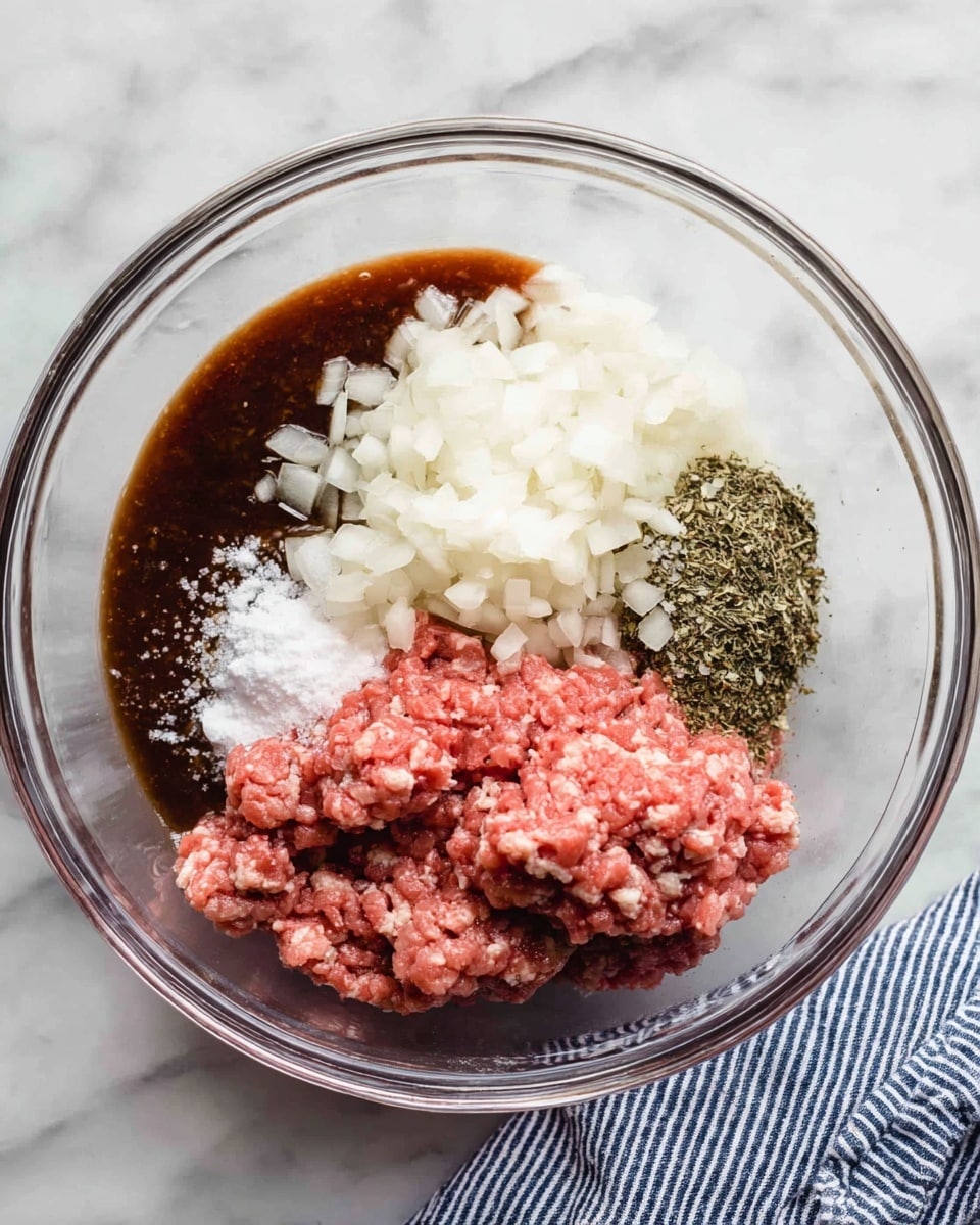 A clear glass bowl sits on a white marbled surface, filled with different ingredients before mixing. The top right side has a mound of raw ground meat in pinkish red, with a slightly loose texture. Below it, to the left, is a pile of finely chopped white onions, giving a crisp and moist look. To the top left side of the bowl, there is a thick dark brown sauce pooled neatly. Next to the sauce, two seasonings stand out: coarse white salt and dried herbs with green and brown shades. A striped blue and white cloth is partially visible at the bottom right corner of the scene. photo taken with an iphone --ar 4:5 --v 7
