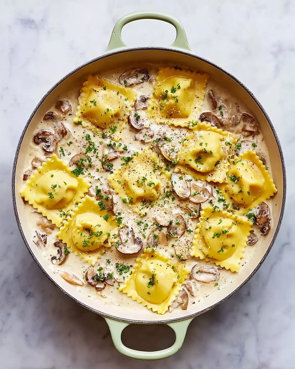 A round white pot with light green handles contains a creamy white sauce with visible pieces of sliced brown mushrooms mixed throughout the sauce. On top of the sauce, there are about thirteen yellow ravioli pieces, each square-shaped with ruffled edges. The ravioli appear soft and tender, arranged evenly across the surface. The dish is sprinkled with small green herb flakes and a light dusting of black pepper. The pot sits on a white marbled surface. Photo taken with an iphone --ar 4:5 --v 7