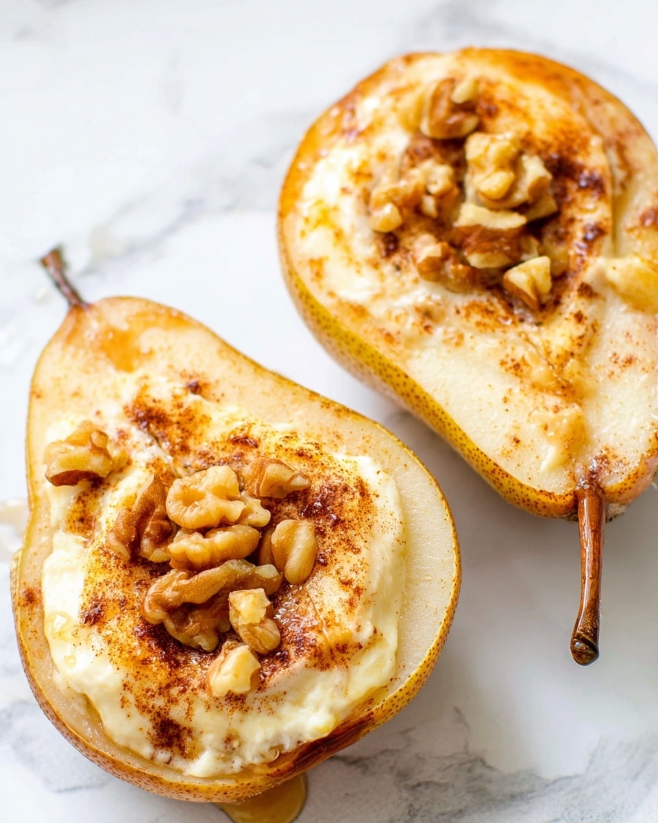 Two pear halves are placed on a white marbled surface, each filled with a soft, pale yellow creamy layer that looks smooth and slightly melted. On top of this creamy layer are scattered pieces of chopped walnuts, which are light brown and textured. The pear skin is a dull greenish-yellow, with the soft inside flesh being a pale cream color. There is a light dusting of cinnamon powder spread evenly over the pears and filling, adding a warm brown tone on top. One pear has a visible brown stem, and the overall look is warm and inviting. Photo taken with an iphone --ar 4:5 --v 7