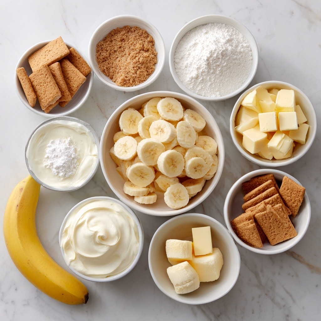 A square slice of layered banana dessert sits on a white plate with crumbs around it, set on a white marbled surface. The dessert has five visible layers: the bottom is a crumbly golden crust, above it are chunks of banana and white creamy filling, followed by a layer of light brown cookie or biscuit pieces, then a thick layer of pale yellow custard or pudding, topped with a thick fluffy white cream layer sprinkled with crushed crumbs and a small thick banana slice on top. The background fades softly with more stacks of light brown cookies blurred behind. Photo taken with an iphone --ar 4:5 --v 7