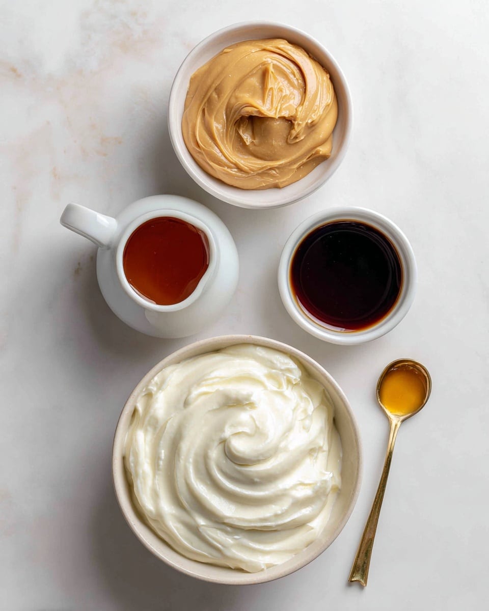 The image shows four white containers placed vertically on a white marbled surface. At the top is a small white bowl filled with creamy light brown peanut butter. Below it, there is a small white jug holding dark amber maple syrup. Underneath the jug, a small gold measuring spoon contains a small amount of dark vanilla extract. At the bottom, a large white bowl is filled with smooth, thick, plain full-fat Greek yogurt that has a soft swirl texture on top. photo taken with an iphone --ar 4:5 --v 7