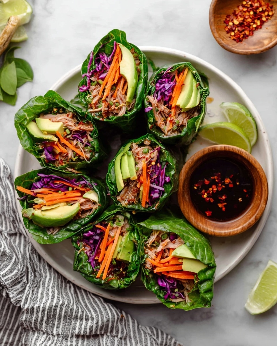 Three fresh spring rolls are stacked vertically on a white plate. Each roll is wrapped in bright green leafy lettuce and filled with layers of purple cabbage, orange shredded carrots, chunks of green avocado, and a beige textured protein mix. The plate sits on a white marbled surface with a half lime and some green herbs placed nearby. The background is softly blurred with a neutral gray tone. photo taken with an iphone --ar 4:5 --v 7