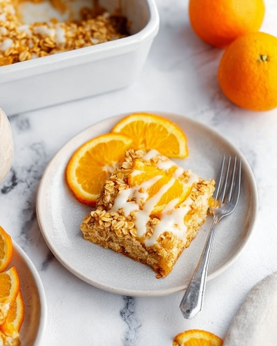 A white plate with a square slice of golden baked oat topping, showing a slightly crunchy texture with creamy white drizzle on top, resting next to bright orange slices with a shiny, juicy texture on the side. A silver fork is placed on the plate, leaning on the orange slices. In the background, there is part of a white baking dish containing the oat-based dessert with a white drizzle and an orange slice on top, placed on a white marbled surface. Two whole bright oranges sit nearby, adding vibrant color to the scene. photo taken with an iphone --ar 4:5 --v 7