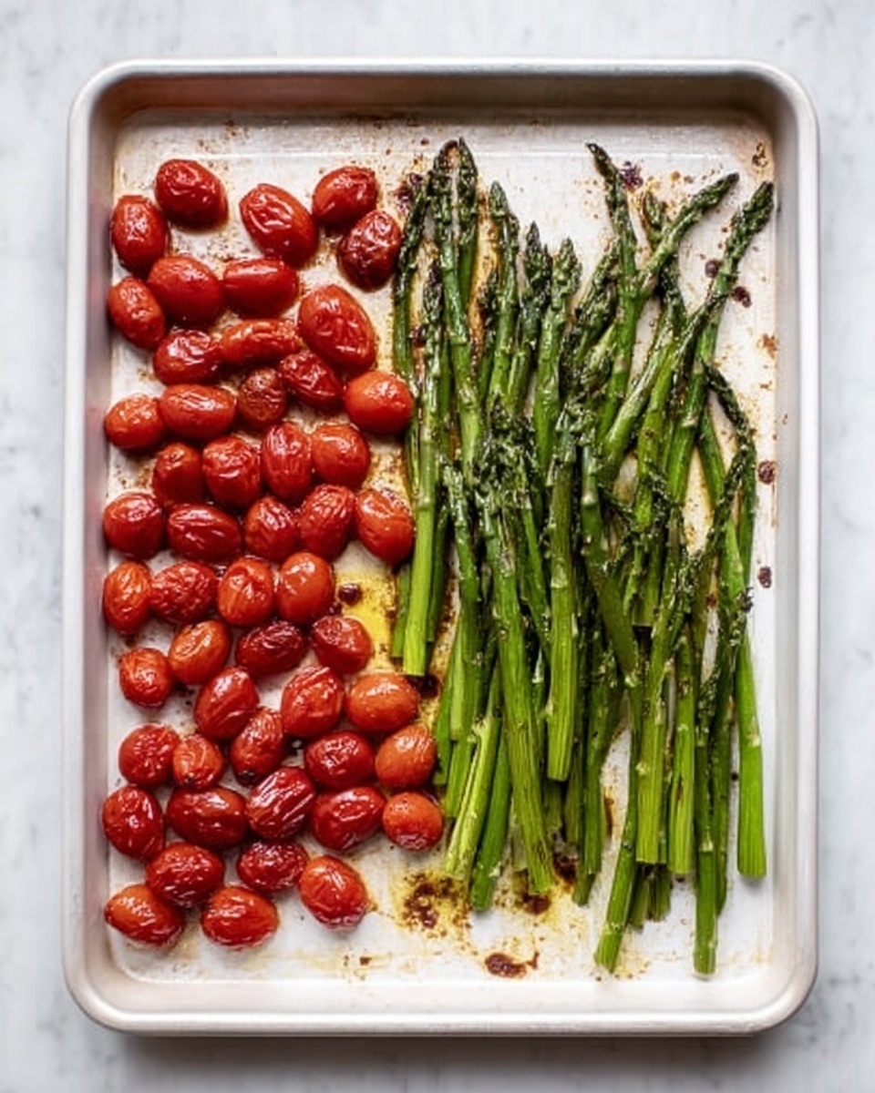 A white baking tray placed on a white marbled surface holds two neat layers of roasted vegetables. On the left side, there is a layer of small, shiny, deep red cherry tomatoes with a shiny, soft texture and slight charring. On the right side, there is a layer of green asparagus spears laid out side by side, showing a slight oil coating with some parts slightly browned and crispy. The contrast between the bright red tomatoes and the rich green asparagus is clear, and the tray shows little roasting residue around the vegetables. Photo taken with an iphone --ar 4:5 --v 7
