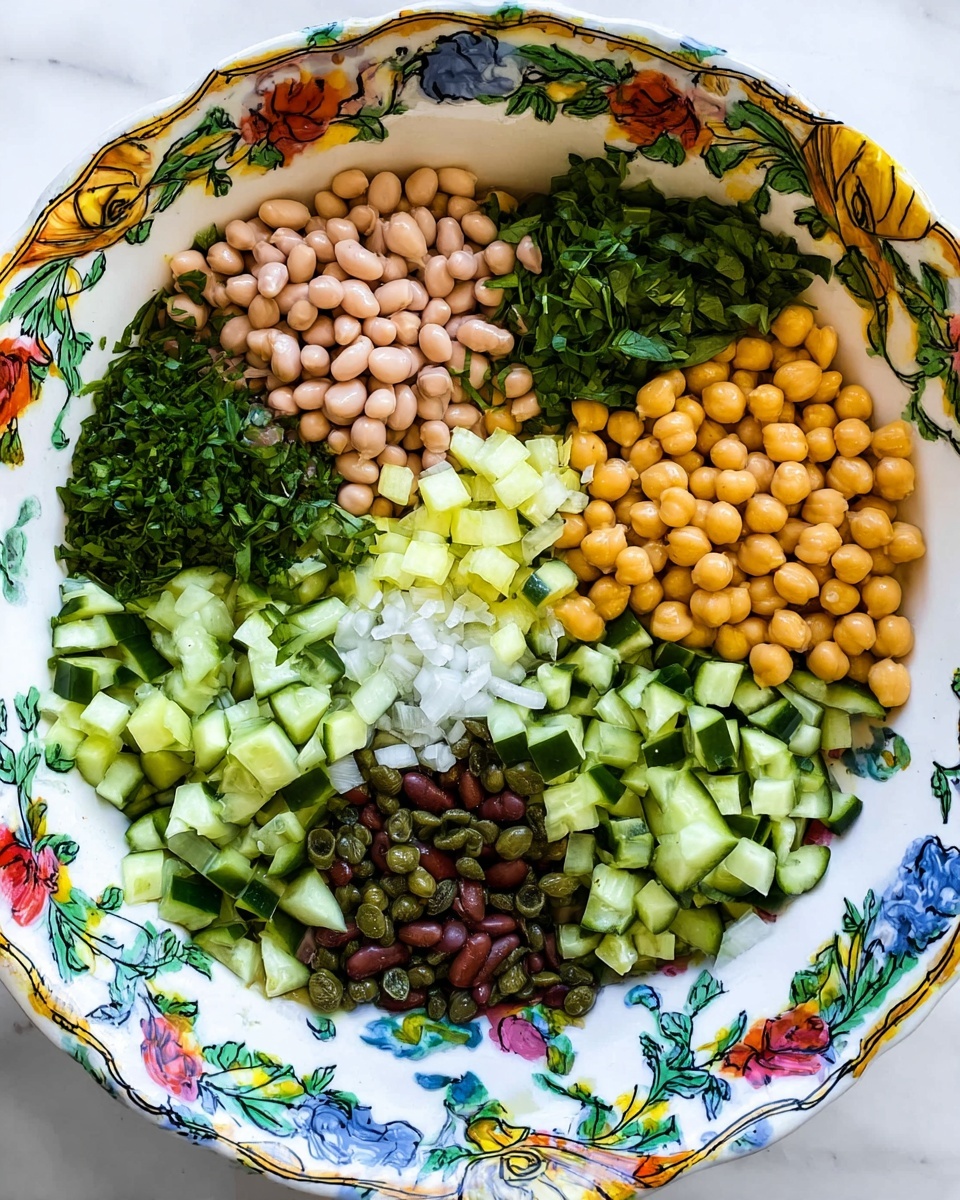 In a large white bowl with colorful floral and blue patterns on the rim, there are six distinct sections of fresh ingredients arranged separately in a circular pattern. Starting at the top and moving clockwise, there are light brown beans with a smooth texture, finely chopped bright green leafy herbs, pale yellow chickpeas that look firm and round, diced crisp cucumber with dark green skin and light green inside, small green capers scattered throughout, and dark brown beans mixed with small pieces of white onion near the center. The white marbled texture surface under the bowl adds a clean and bright background. photo taken with an iphone --ar 4:5 --v 7