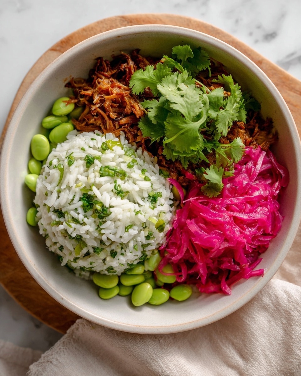 A white bowl holds three main parts: a mound of white rice mixed with bright green edamame and small green herbs, positioned in the front; next to it on the right is a pile of bright pink shredded cabbage or pickled vegetables, with fresh green cilantro leaves scattered on top; behind the rice at the back is a layer of shredded brown cooked protein, topped with more cilantro sprigs. The bowl sits on a white marbled surface with part of a soft beige cloth visible nearby. Photo taken with an iphone --ar 4:5 --v 7